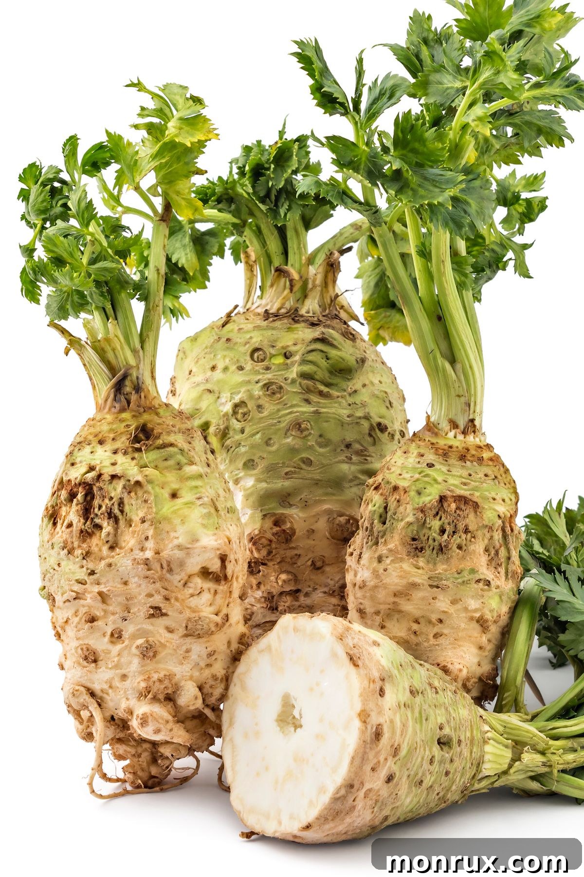 Celery roots with a celeriac sliced in half.