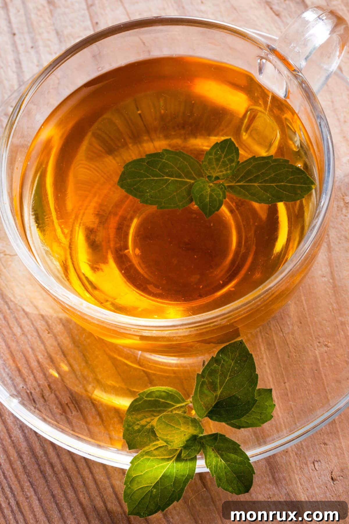 Close up view of tea in a glass with mint on top.
