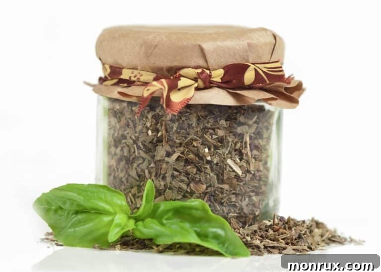 Glass jar filled with dry basil with a paper top.