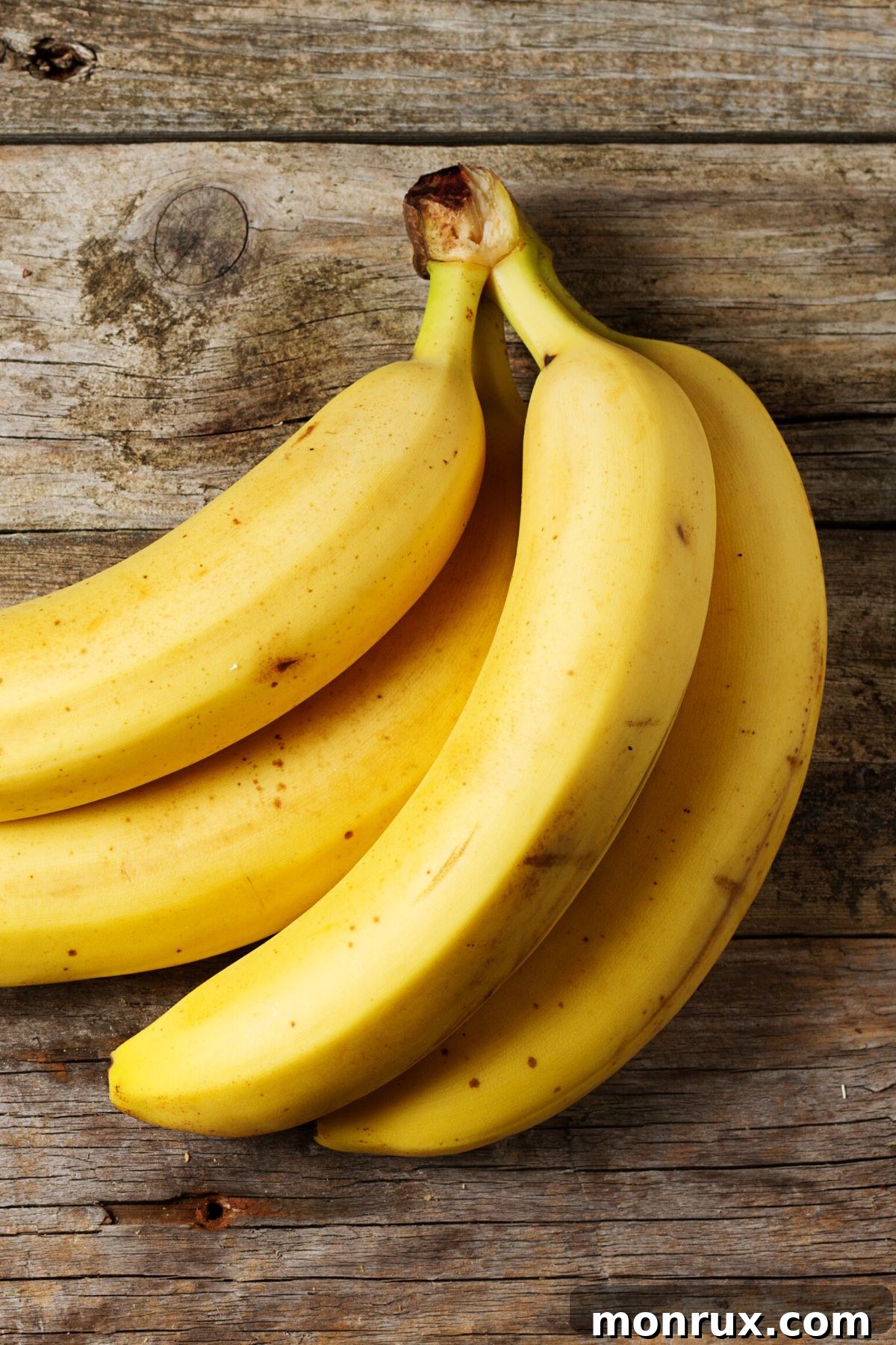 A bunch of fresh, ripe bananas on a table, ready for freezing.