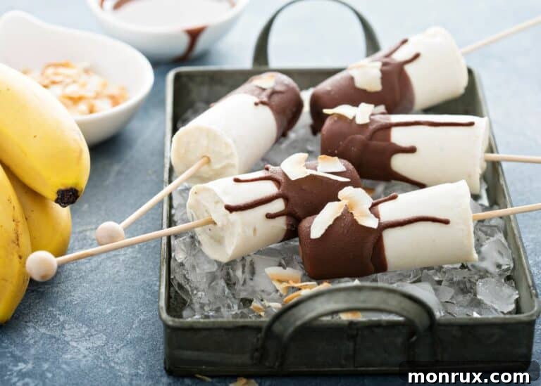 Banana popsicles covered in chocolate sitting in a pan with ice.