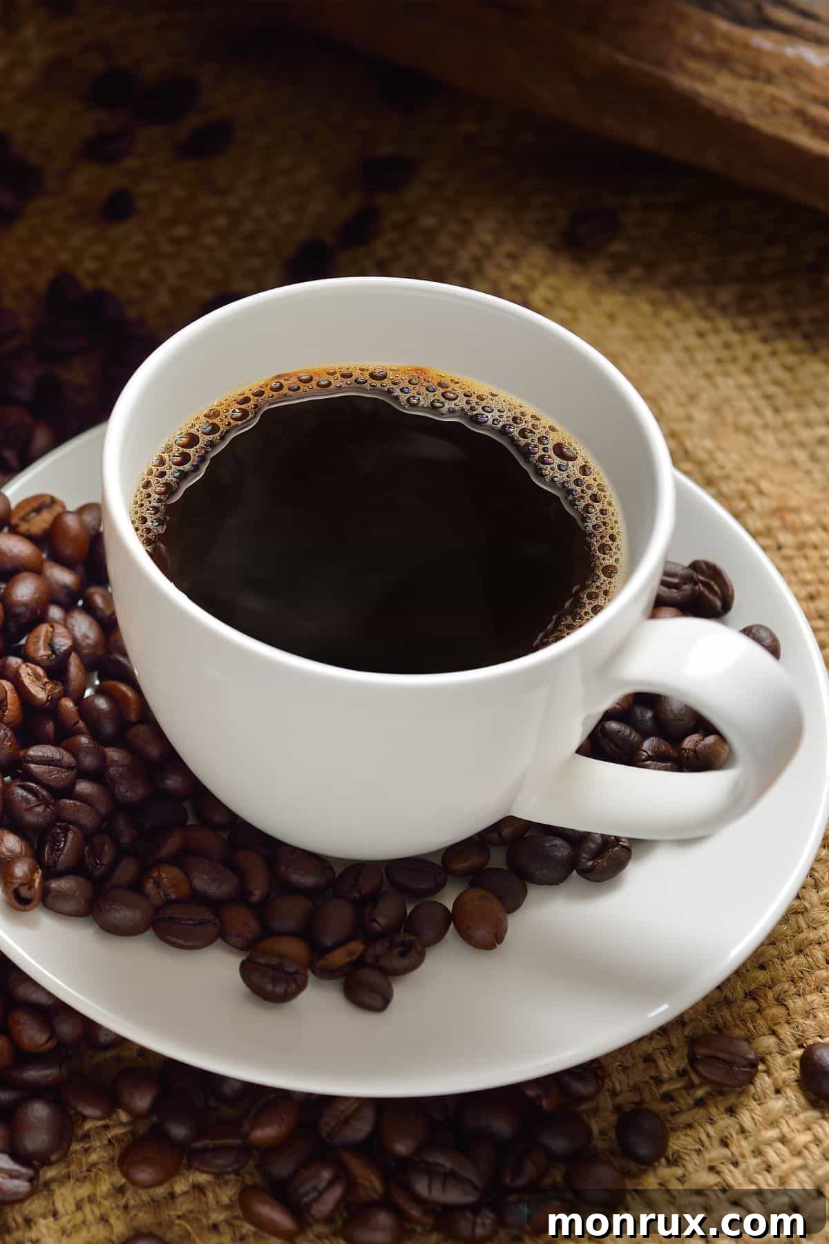 A steaming mug of low acid coffee, symbolizing comfort and rich flavor, surrounded by whole coffee beans and a cozy ambiance.