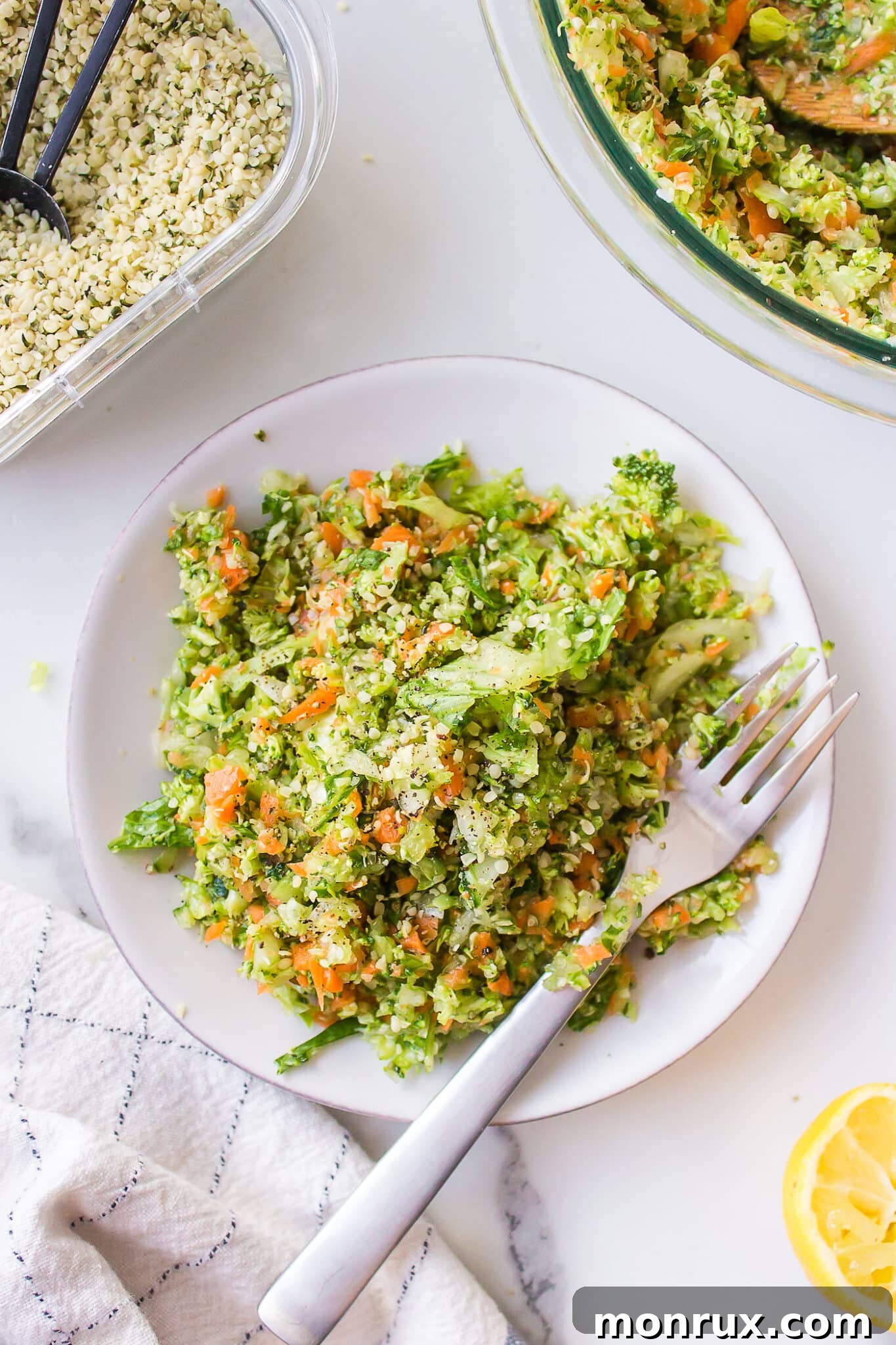 A serving of chopped veggie salad on a small white plate with a fork.