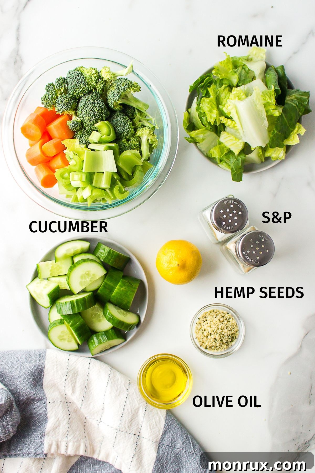 Ingredients for chopped veggie salad in small bowls on a white surface.