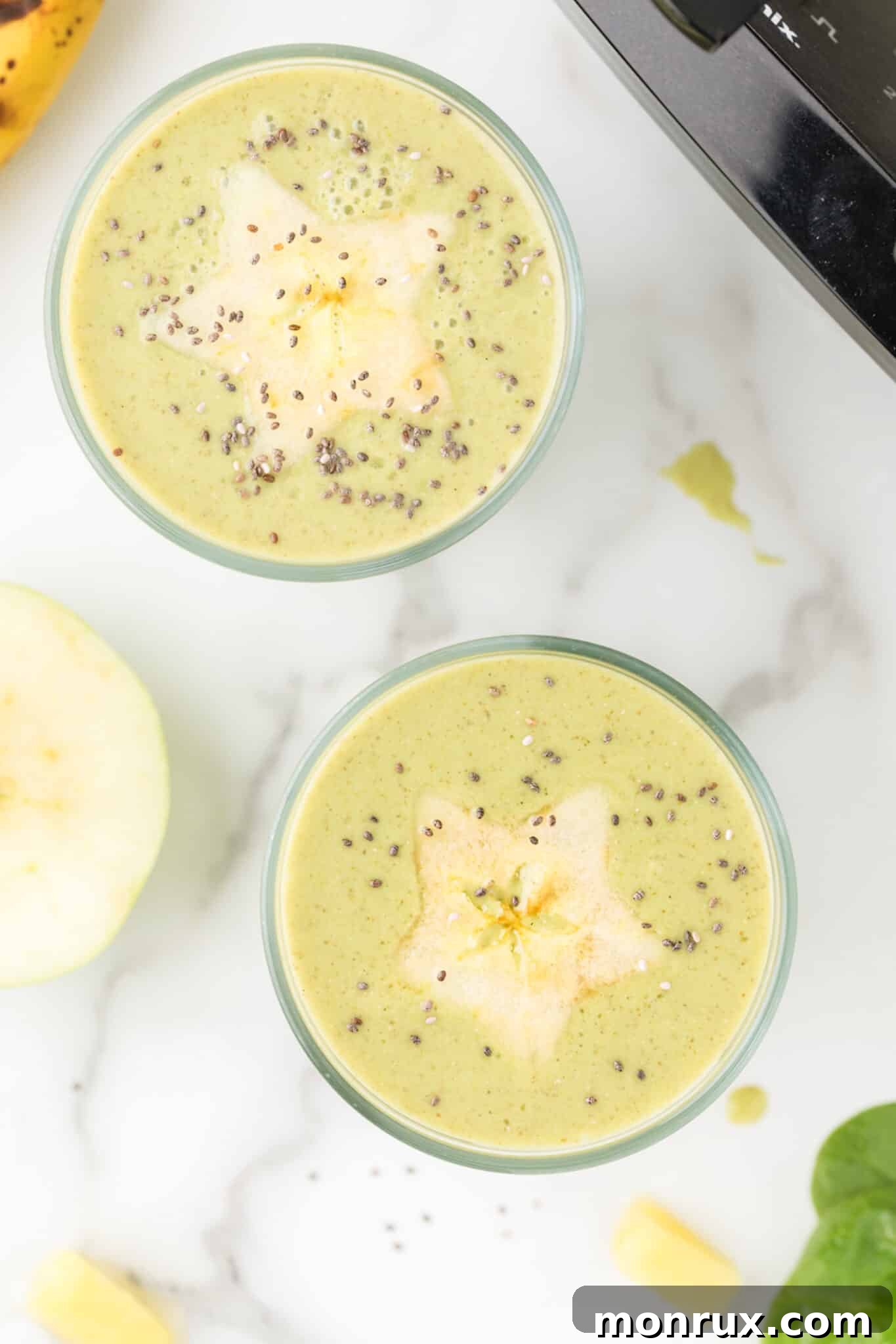 Two glasses of spinach smoothie topped with starfruit and chia seeds for a beautiful presentation.