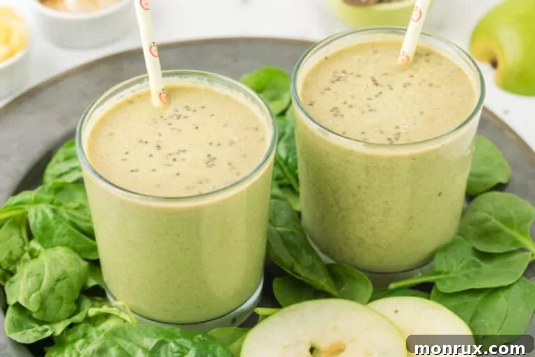 Two short glasses of apple banana smoothie with chia seeds, garnished for serving.
