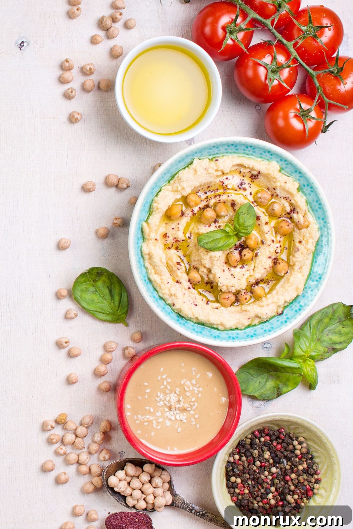 A coloful bowl filled with hummus ahd chickpeas, garnished with fresh herbs and a drizzle of olive oil.