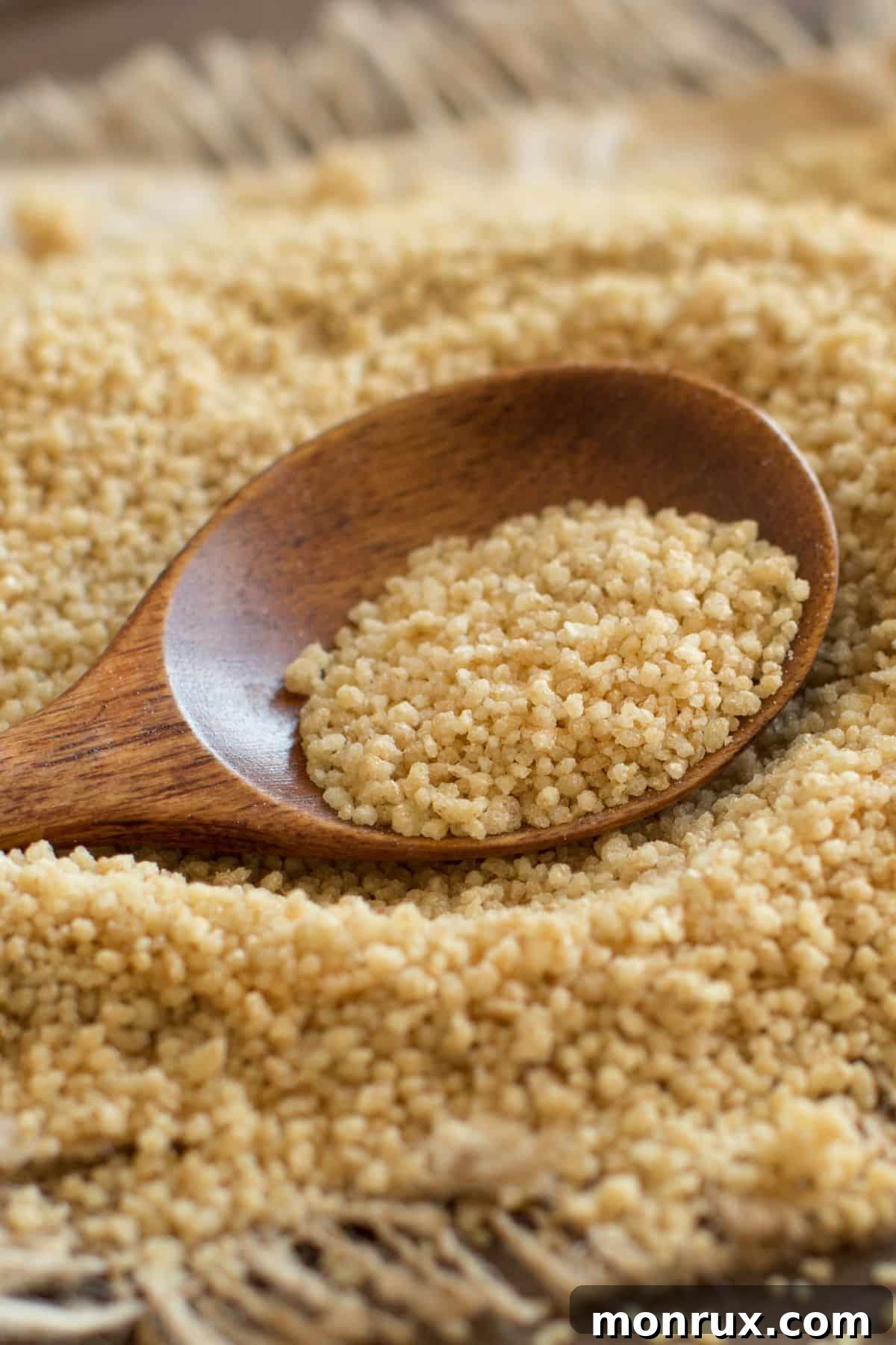 Scoop of couscous on tabletop surface.