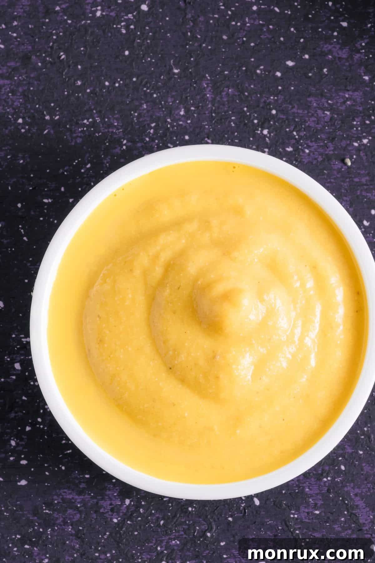 Bowl of vegan cheese sauce on countertop.