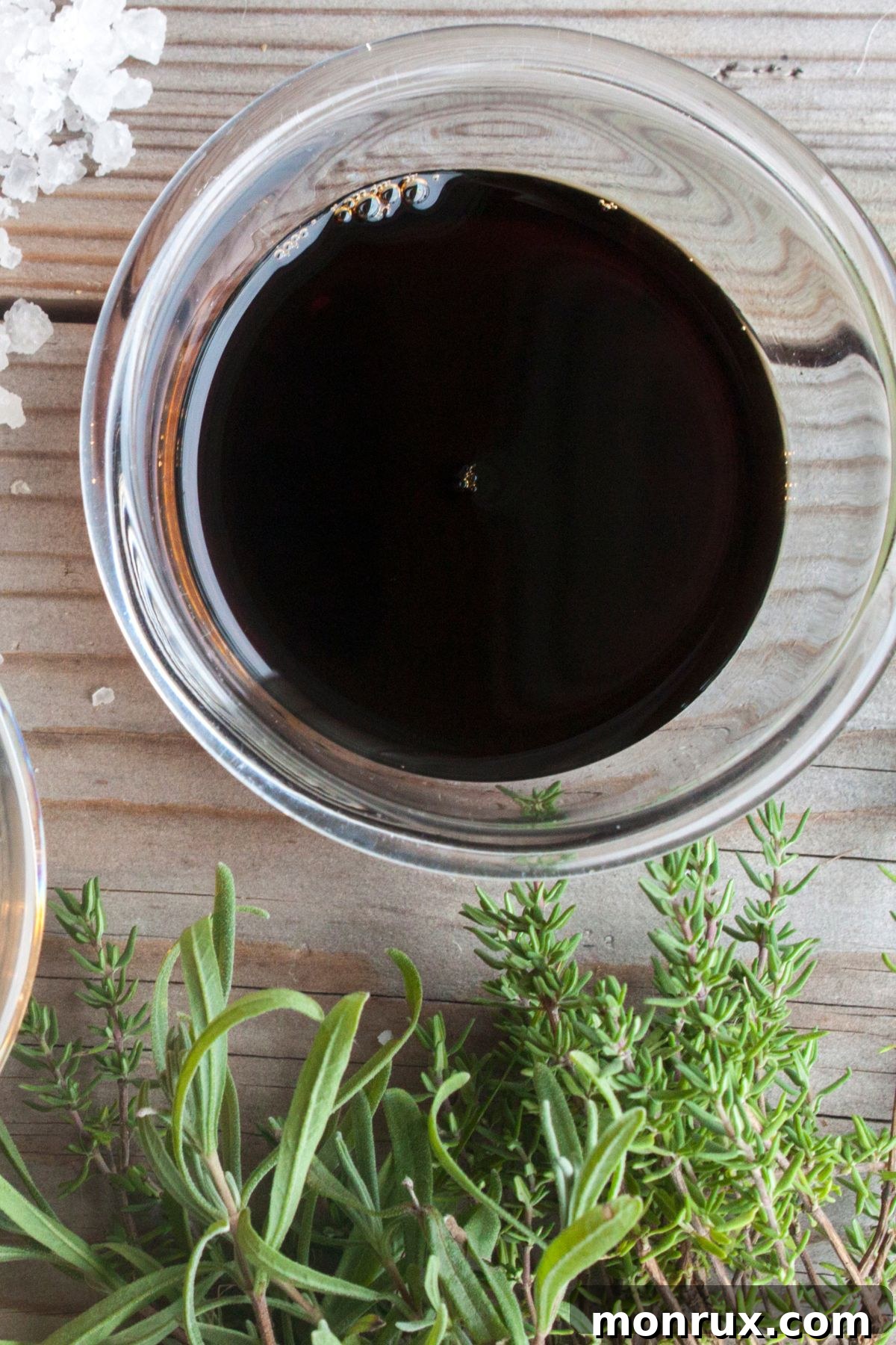 Bowl of liquid aminos on wooden surface.