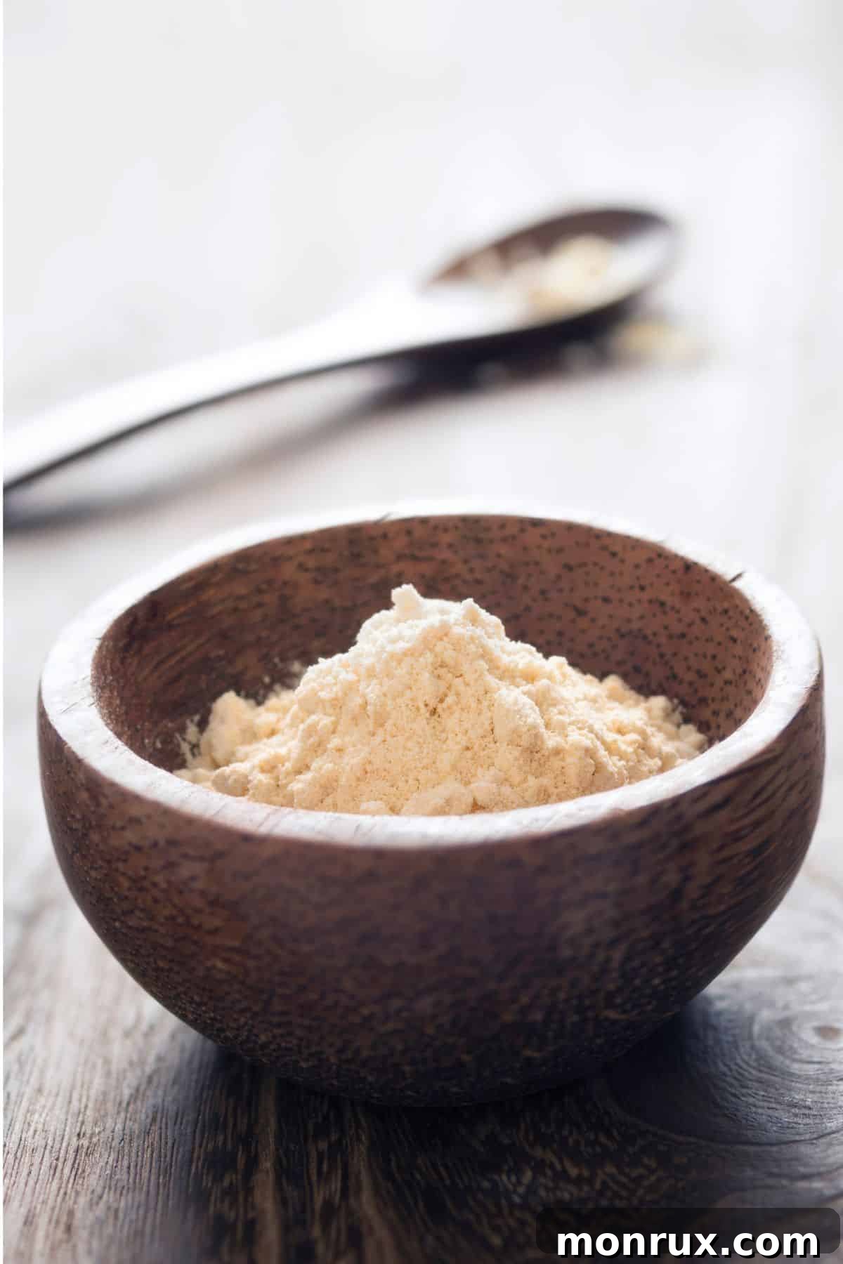 Bowl of chickpea flour on wooden surface.