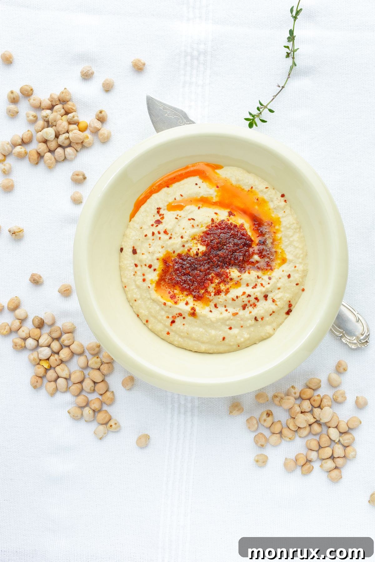 A bowl of creamy, healthy hummus on a textured counter, ideal for a soft diet.