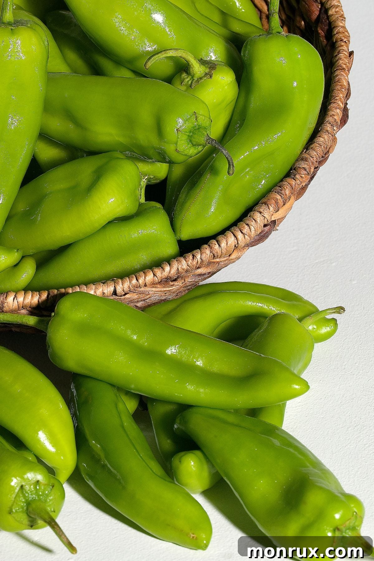 Basket of green chilis on tabletop.