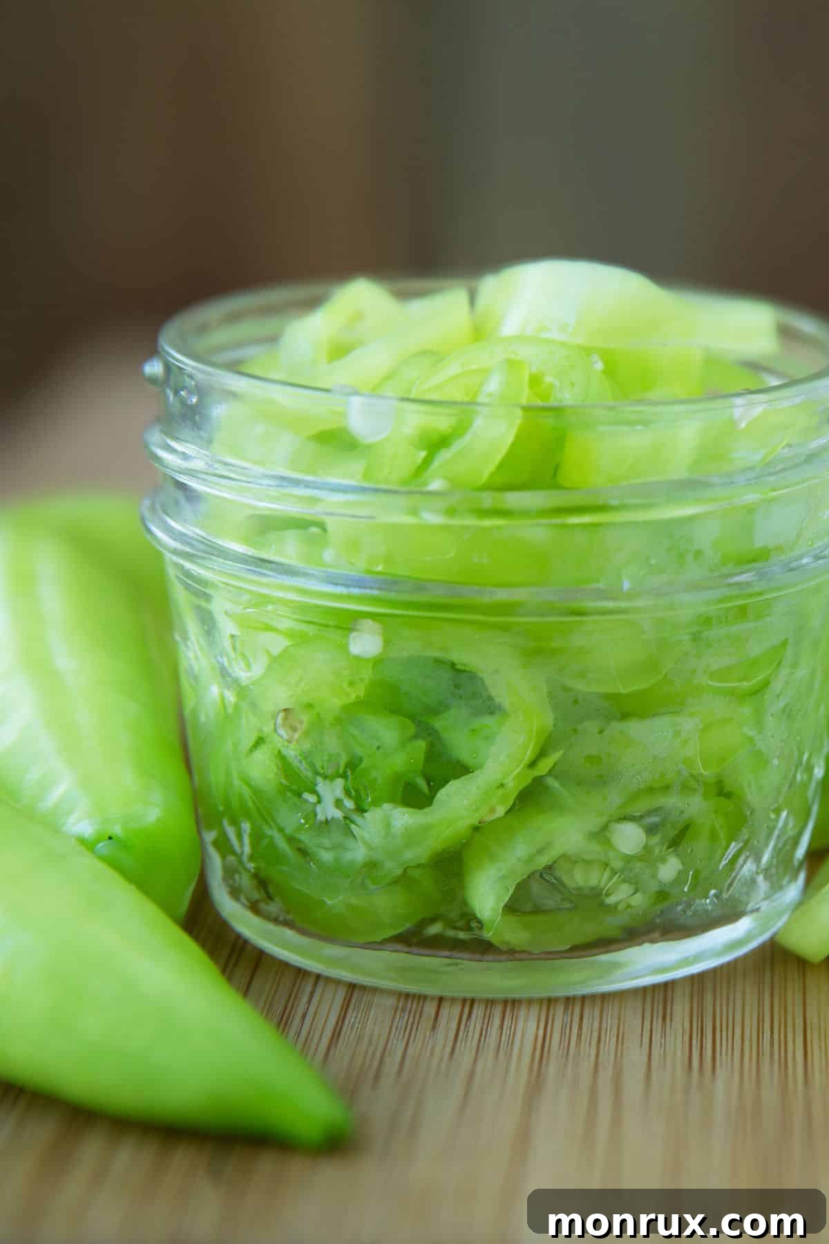 Jar of sliced banana peppers with whole banana peppers.
