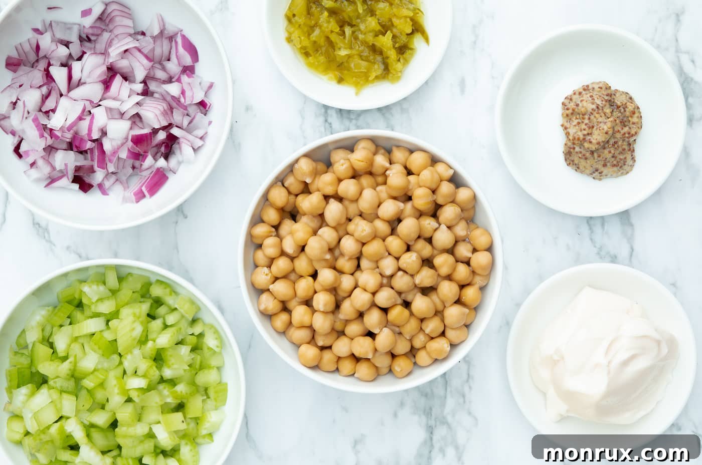 Essential ingredients for vegan chickpea tuna salad laid out on a surface.