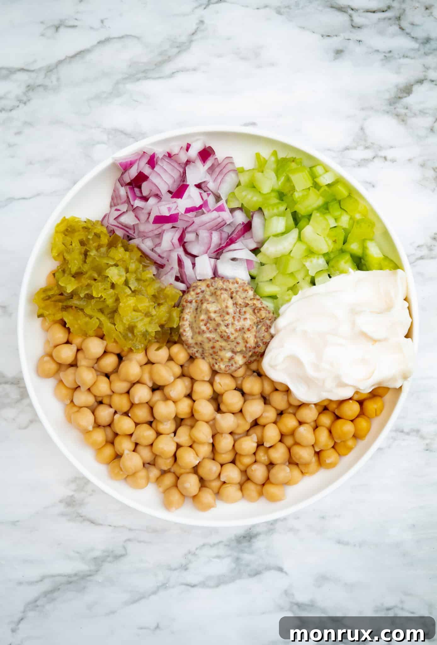 Step-by-step process of mixing vegan chickpea tuna salad ingredients.