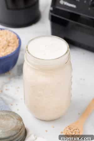 A mason jar of homemade oat milk creamer, ready to be added to coffee.
