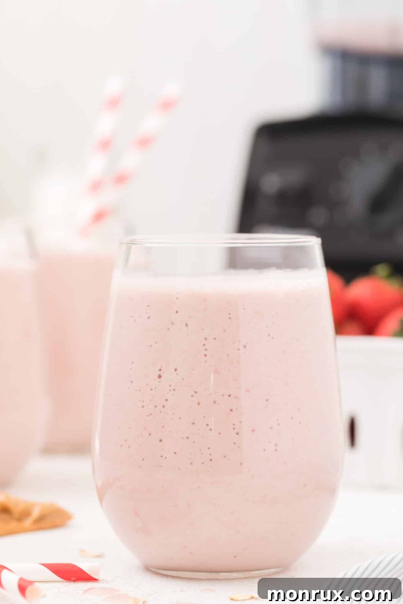 A glass of creamy strawberry beef protein smoothie, garnished with a fresh strawberry, ready to be enjoyed.