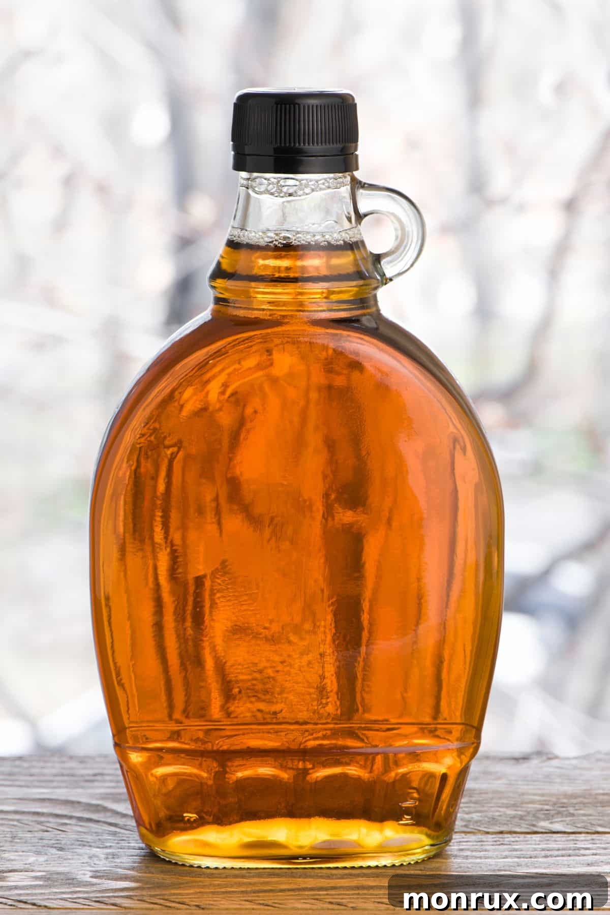 Bottle of maple syrup on wooden surface.