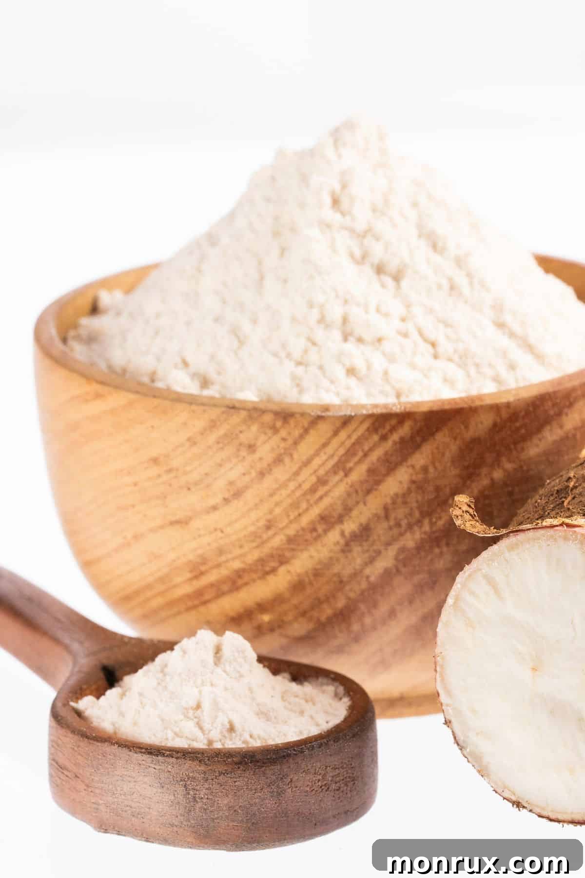 Bowl and spoonful of arrowroot starch with fresh arrowroot.