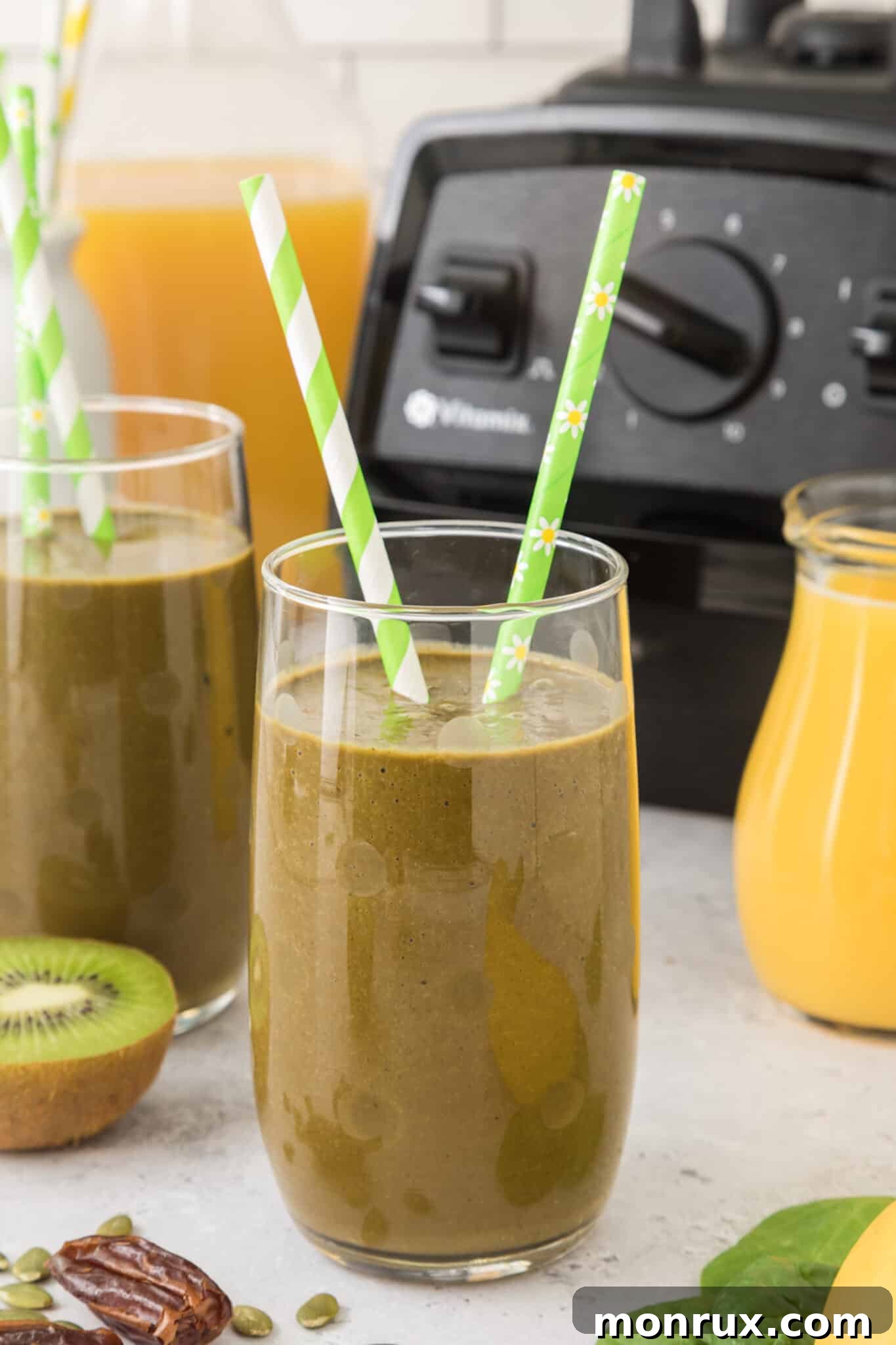 A vibrant green iron-rich smoothie in a tall glass, garnished with two striped green straws, ready to be enjoyed as a healthy, energizing drink.