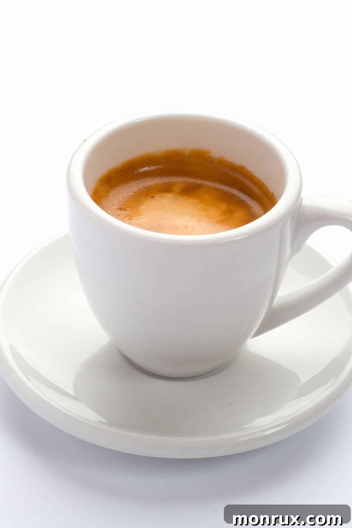 A perfectly pulled shot of espresso in a classic white ceramic espresso cup and saucer.