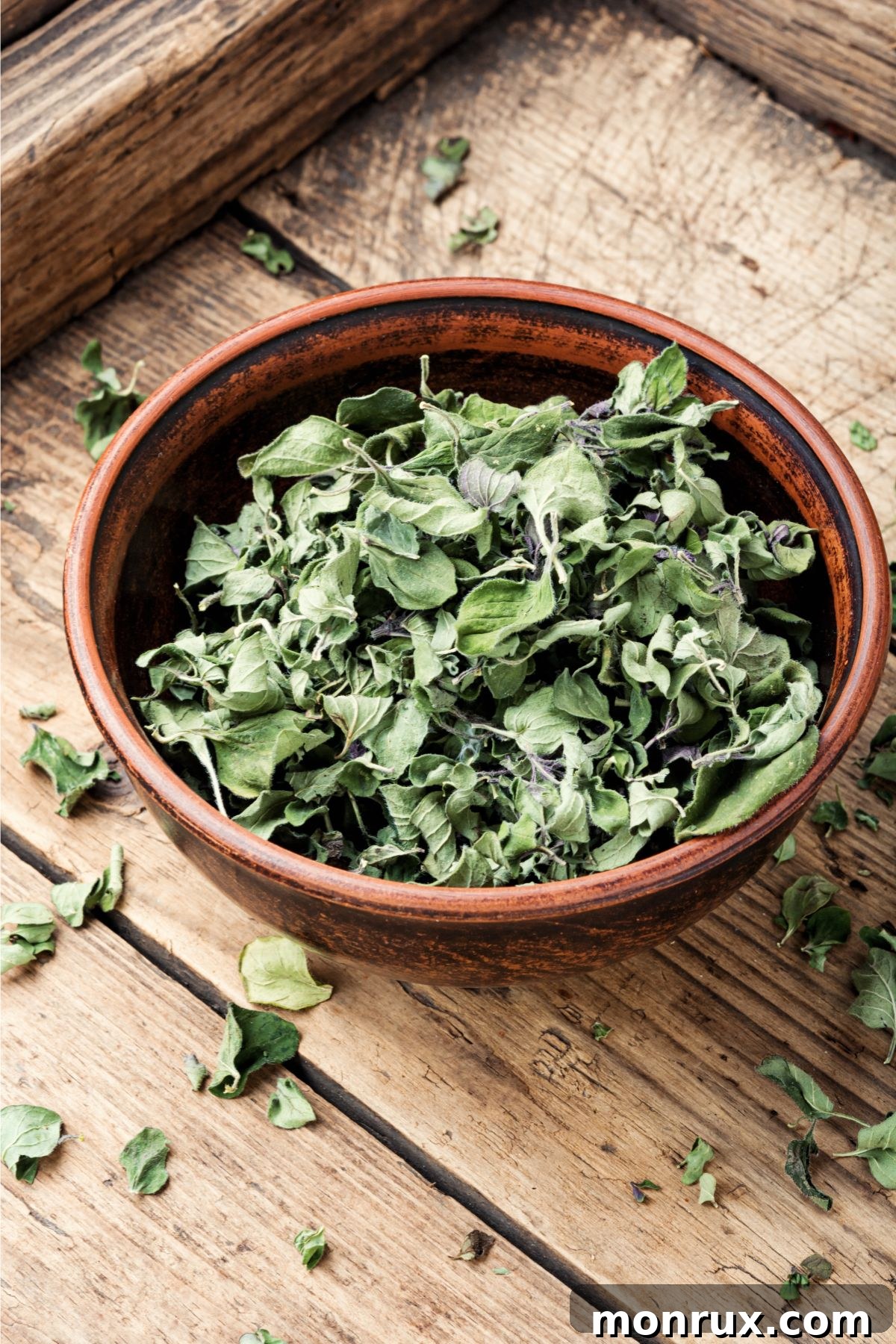Bowl of dried oregano on a rustic wooden surface, demonstrating a key substitute for dried basil.