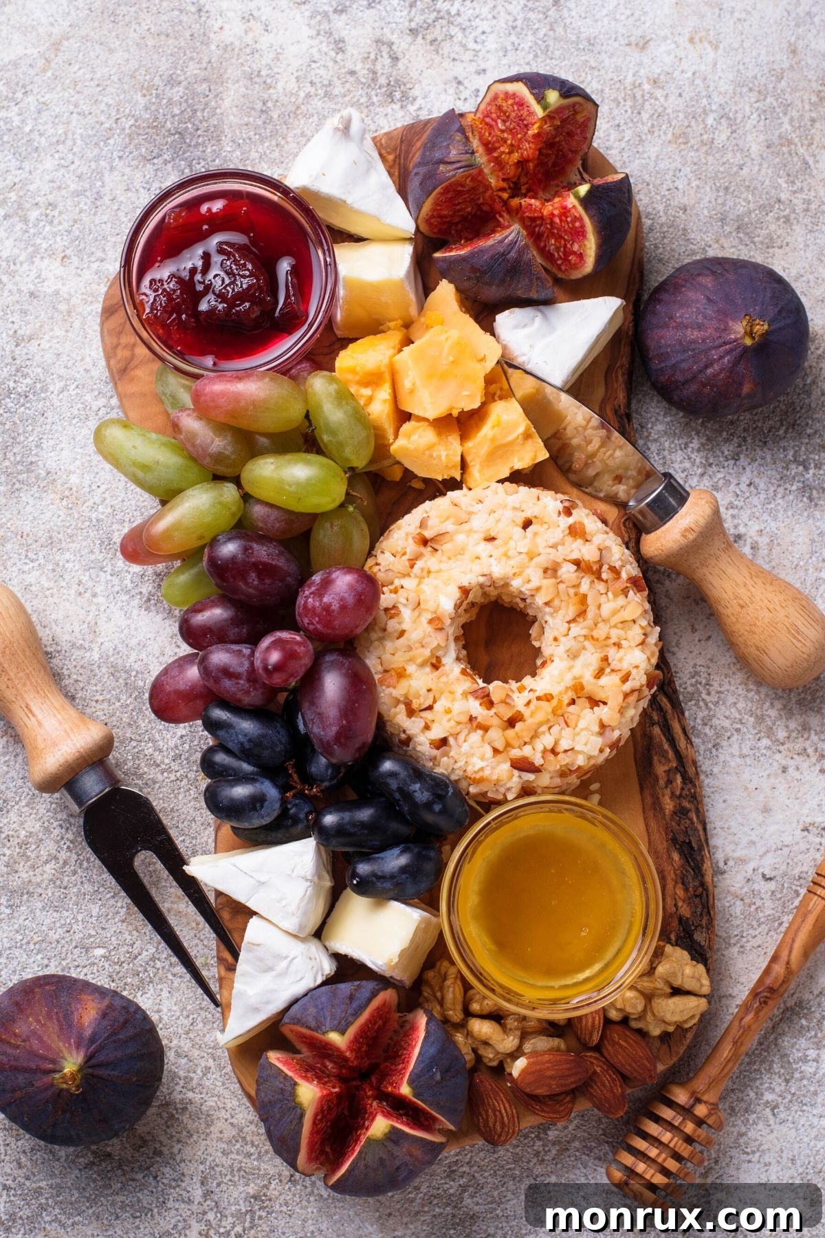 Cheeseboard with grapes, figs, and jam.