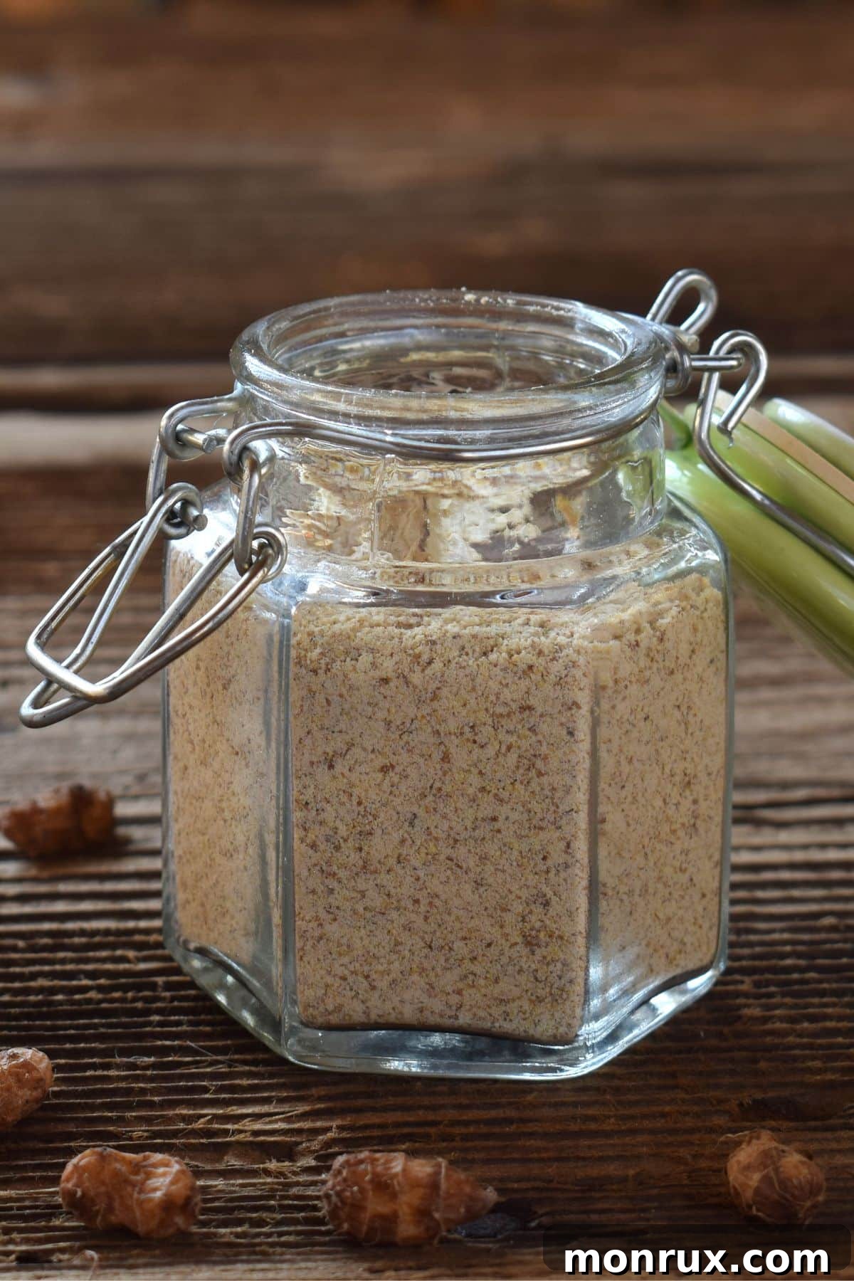 Jar of tigernut flour on a rustic wooden surface, surrounded by raw tigernuts, highlighting its natural origin and readiness for baking.