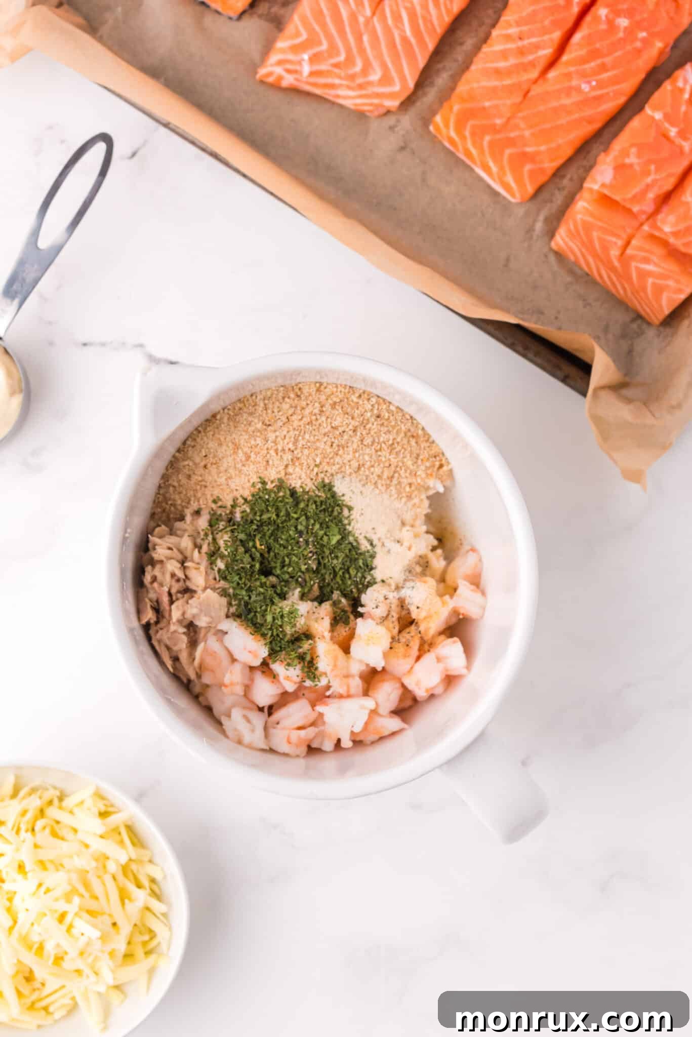 A bowl filled with a creamy and savory seafood stuffing mixture for salmon.