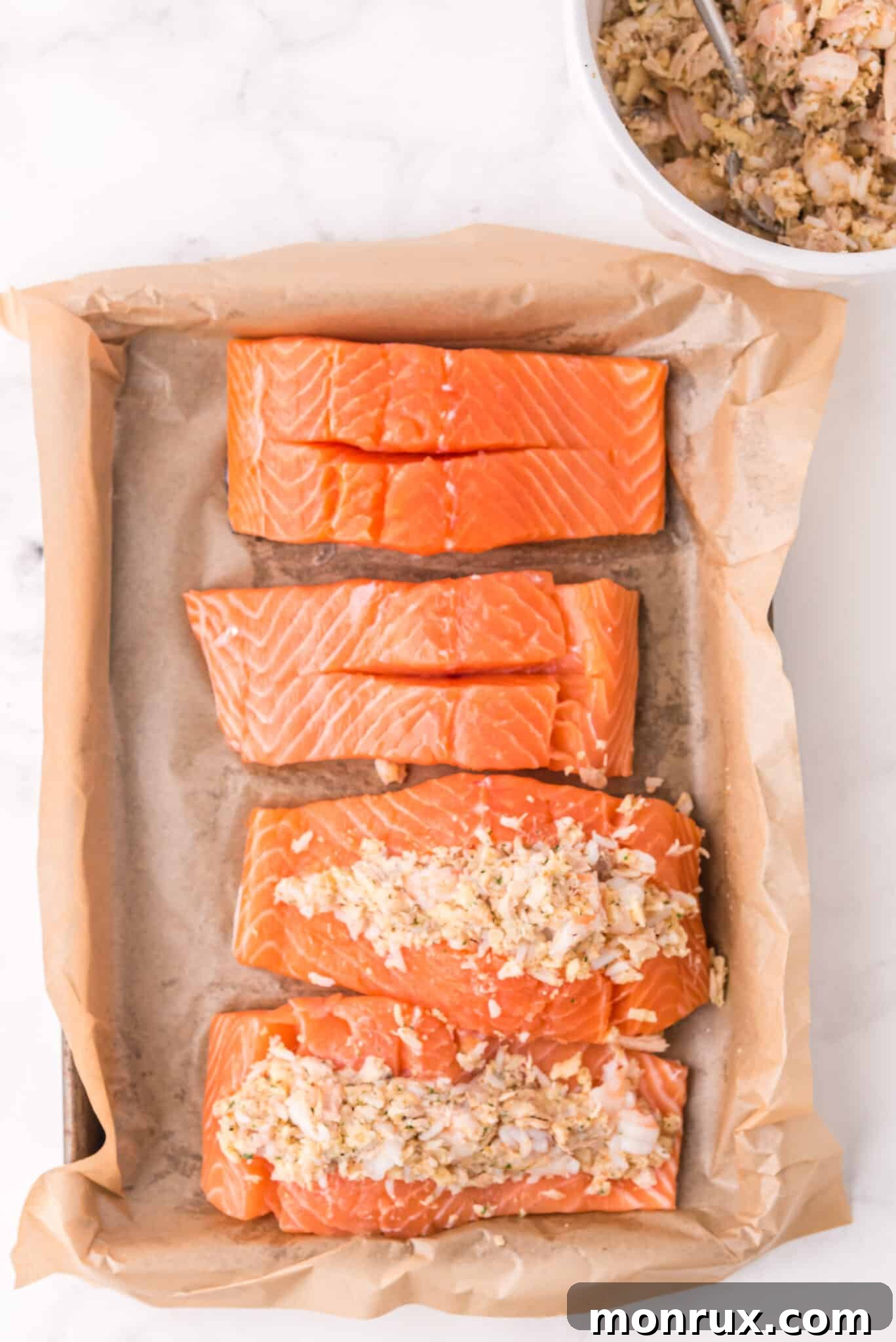 Illustrative image demonstrating how to gently stuff the seafood mixture into the pre-cut pockets of salmon fillets.