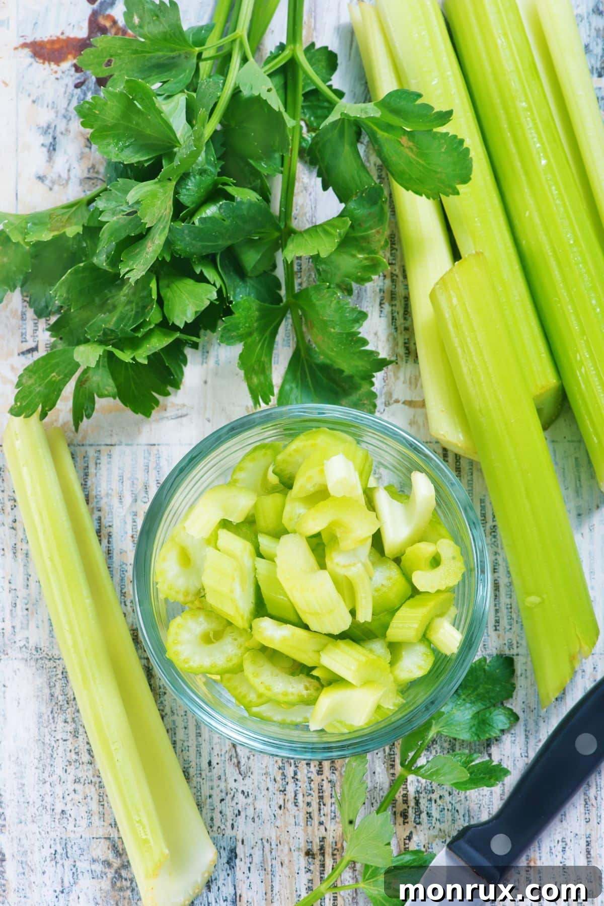 Sliced and chopped bowl of celery on white surface.