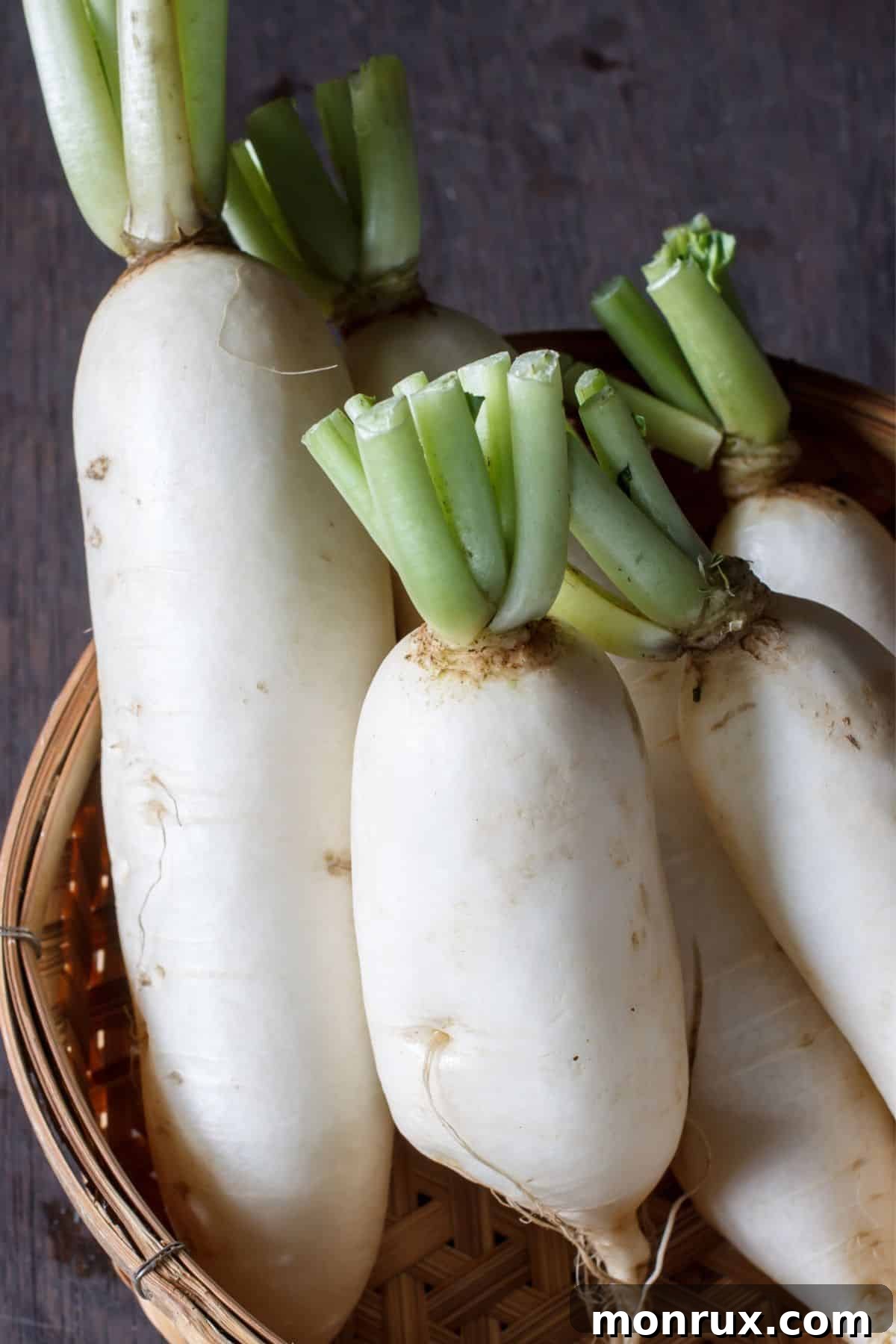 Basket of daikon radish on wooden surface.