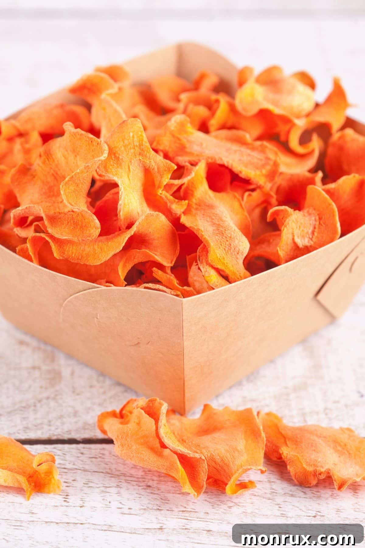 Dehydrated carrots in a rustic cardboard box, ready for storage.