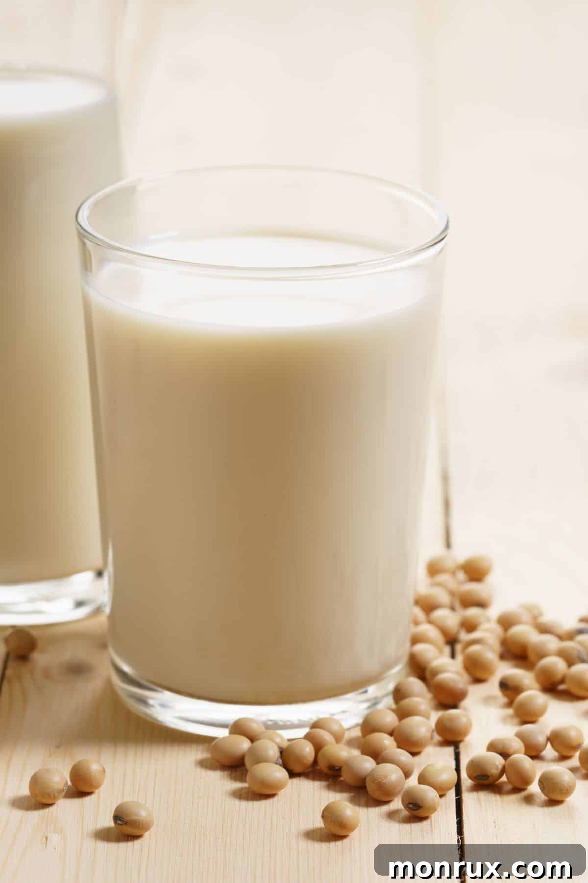 a cup of soy milk surrounded by soy beans.