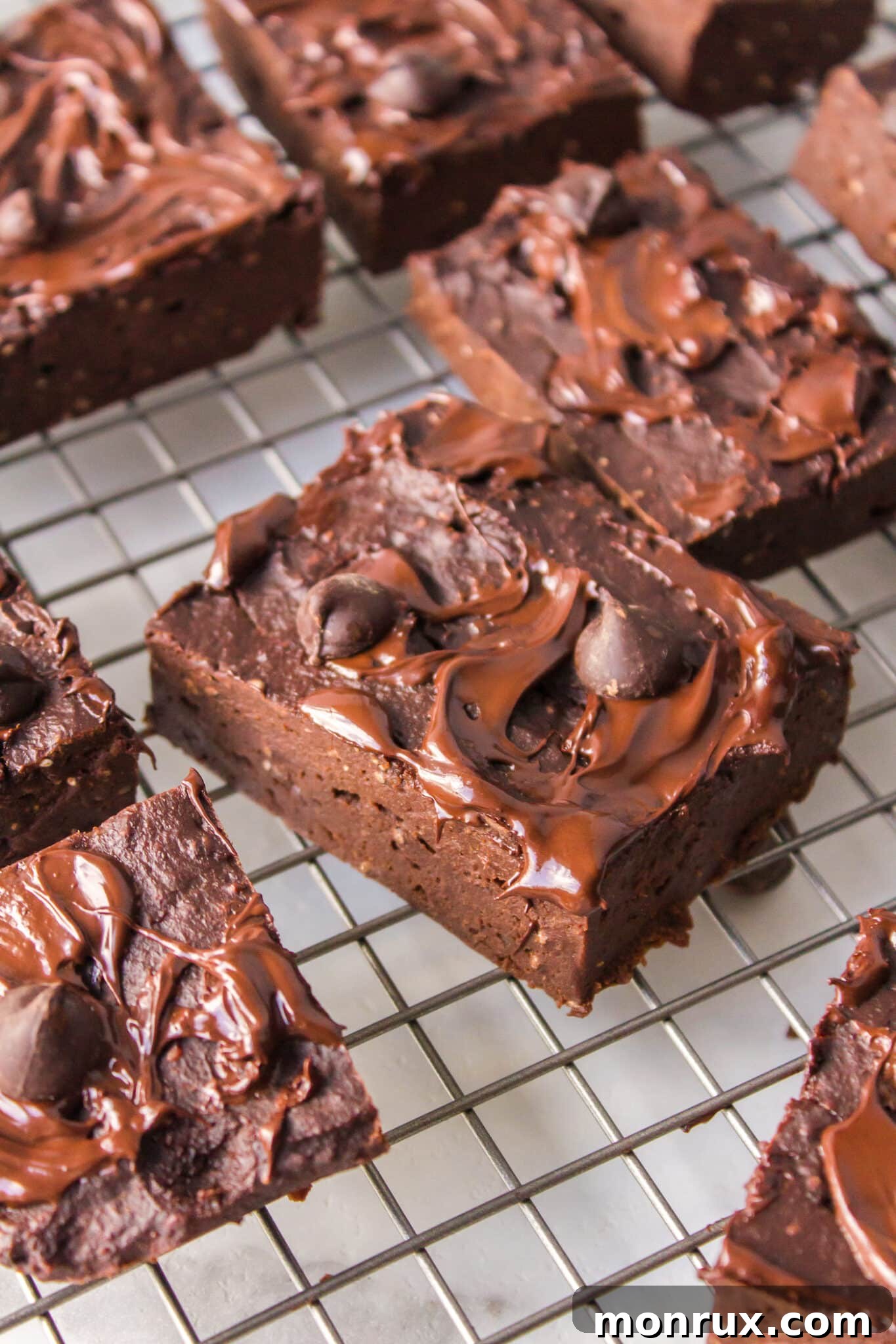 Deliciously moist vegan pumpkin brownie squares cooling on a wire rack, ready to be enjoyed.
