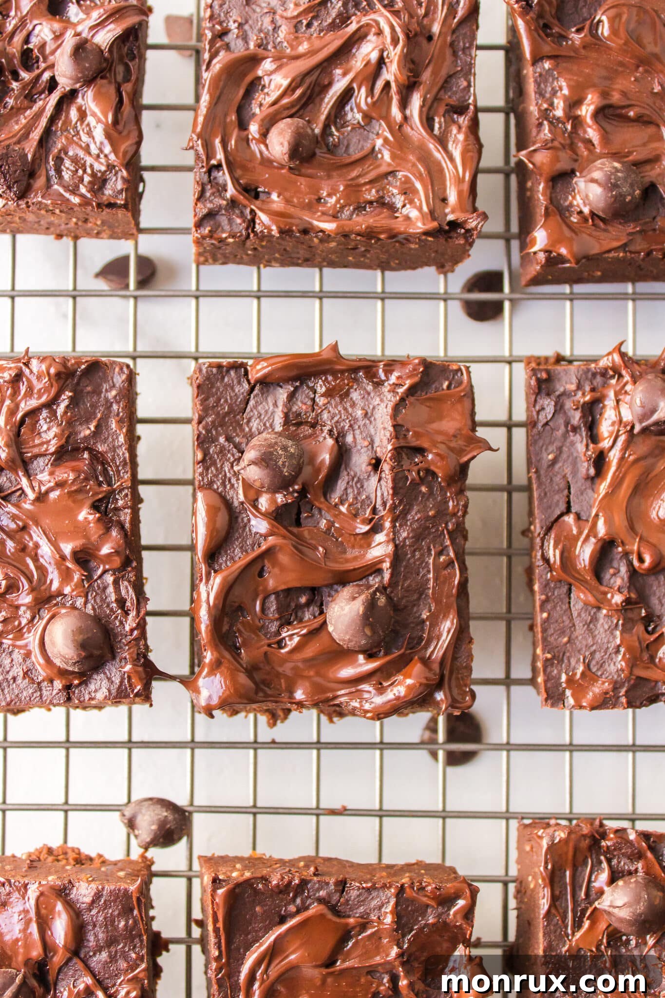 Perfectly sliced vegan pumpkin brownies resting on a wire cooling rack, showcasing their rich, fudgy interior.