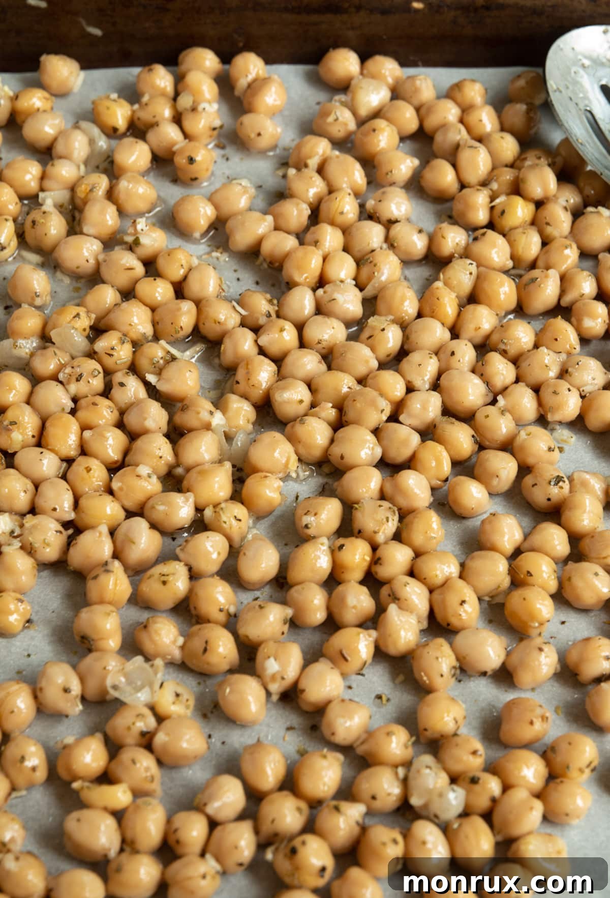 A baking sheet filled with golden brown, crispy roasted chickpeas, fresh out of the oven and cooling.