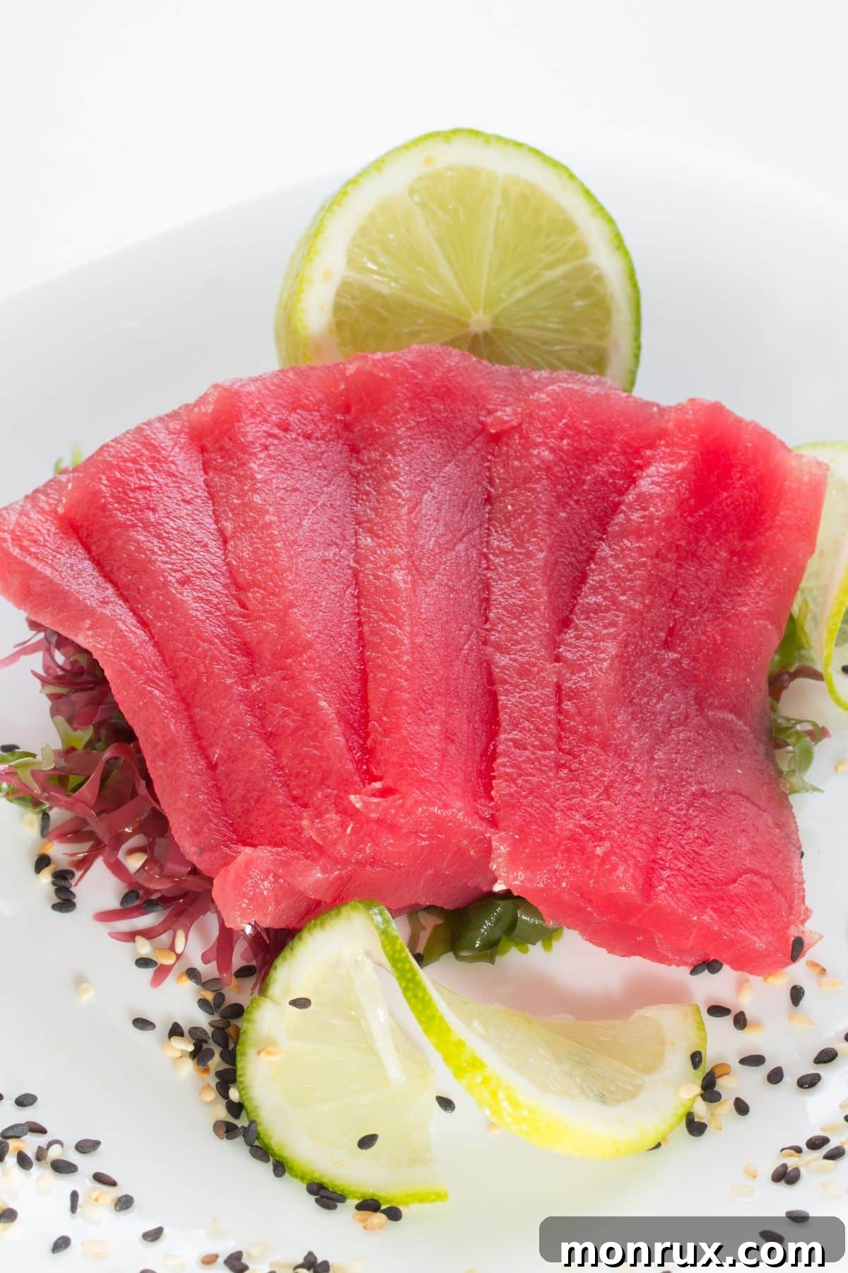 Slices of tuna fillet with lime and sesame seeds.