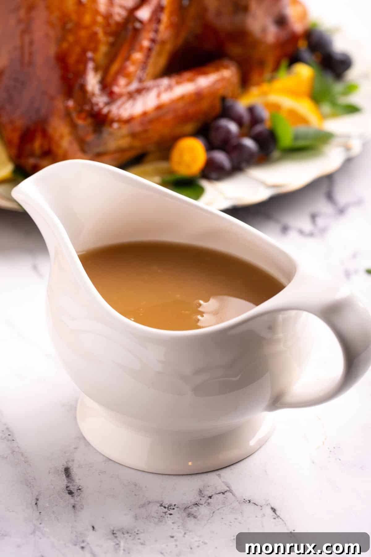 A pristine white gravy boat overflowing with homemade, golden-brown dairy-free turkey gravy, ready to be served.