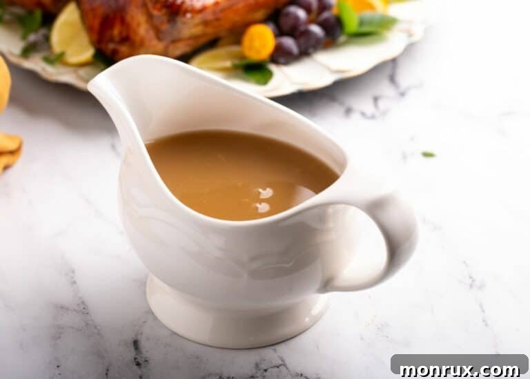 A white gravy boat filled with homemade turkey gravy.