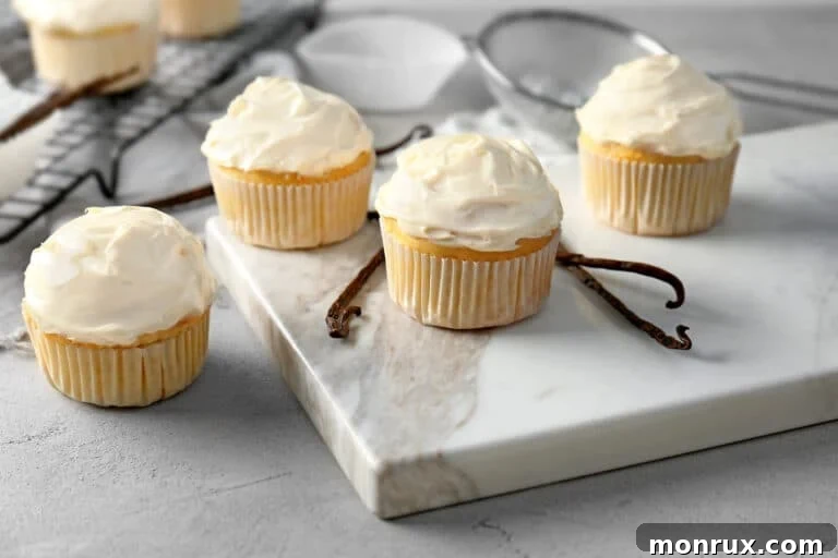Vanilla cupcakes on a white marble surface, demonstrating the finished product.