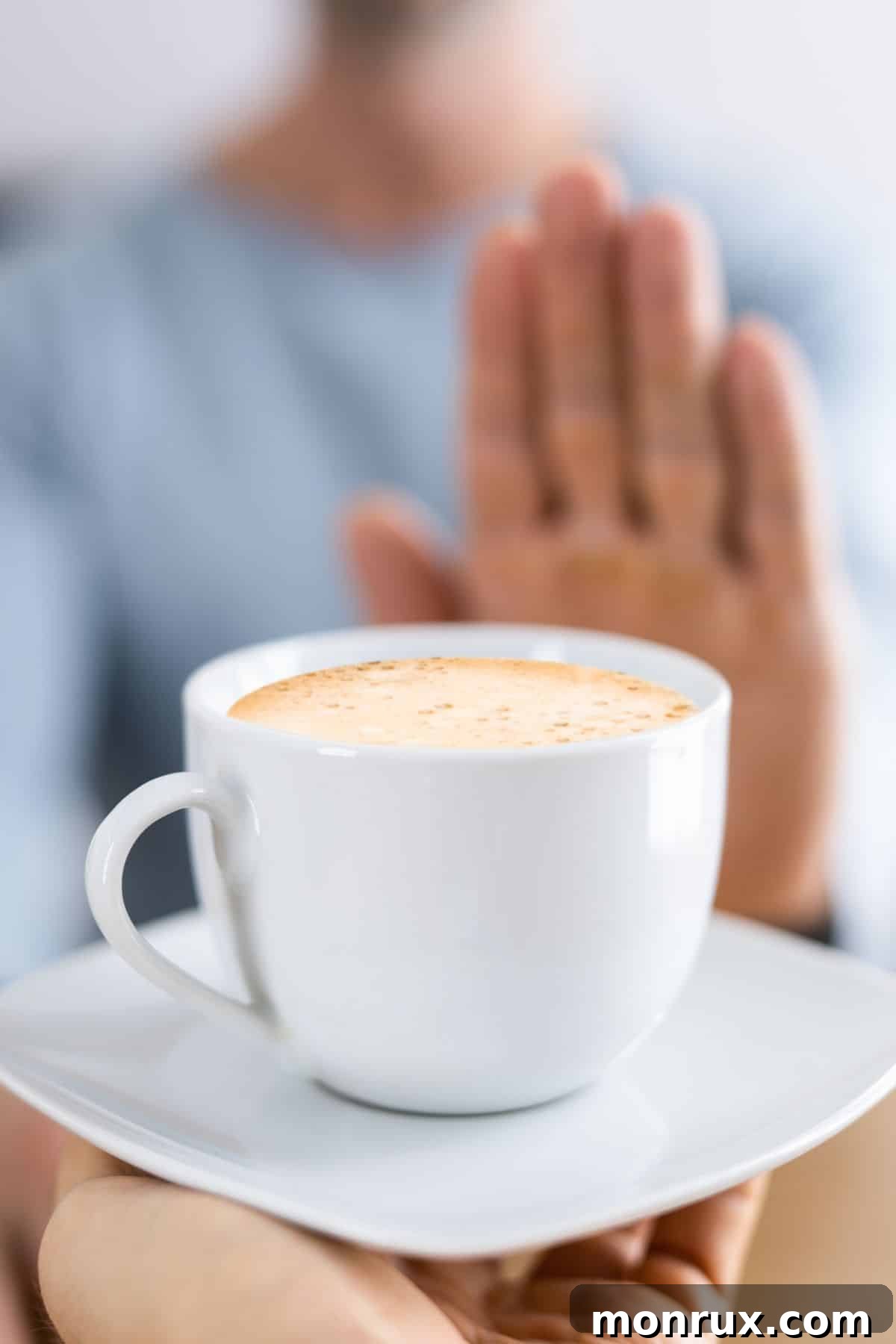 woman pushing away a mug of coffee.