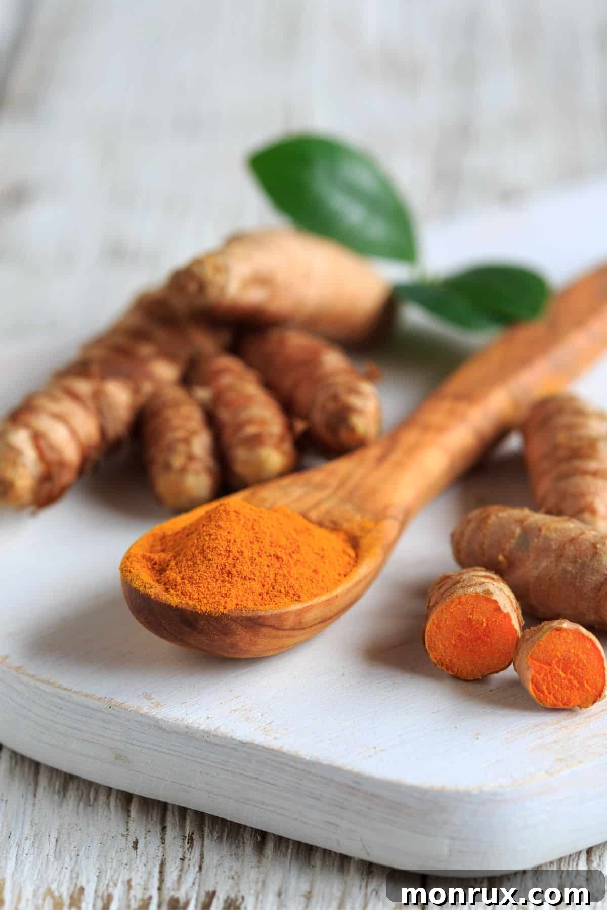 Vibrant turmeric roots arranged on a wooden cutting board, highlighting the spice's natural and potent properties for liver health.