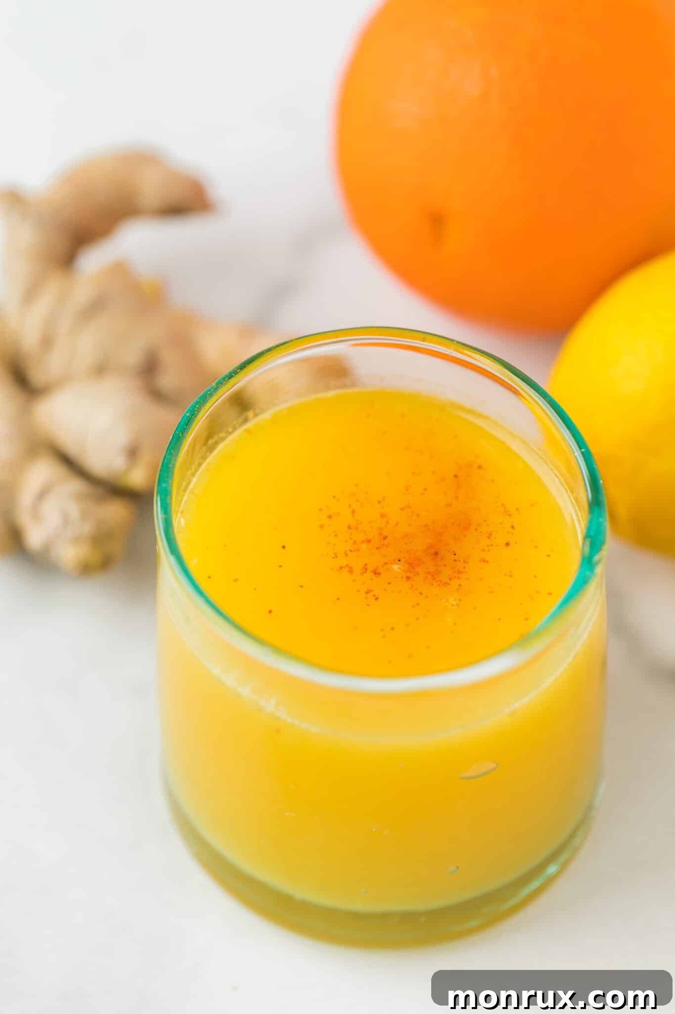 Vibrant yellow ginger shot in a small glass, symbolizing health and vitality.