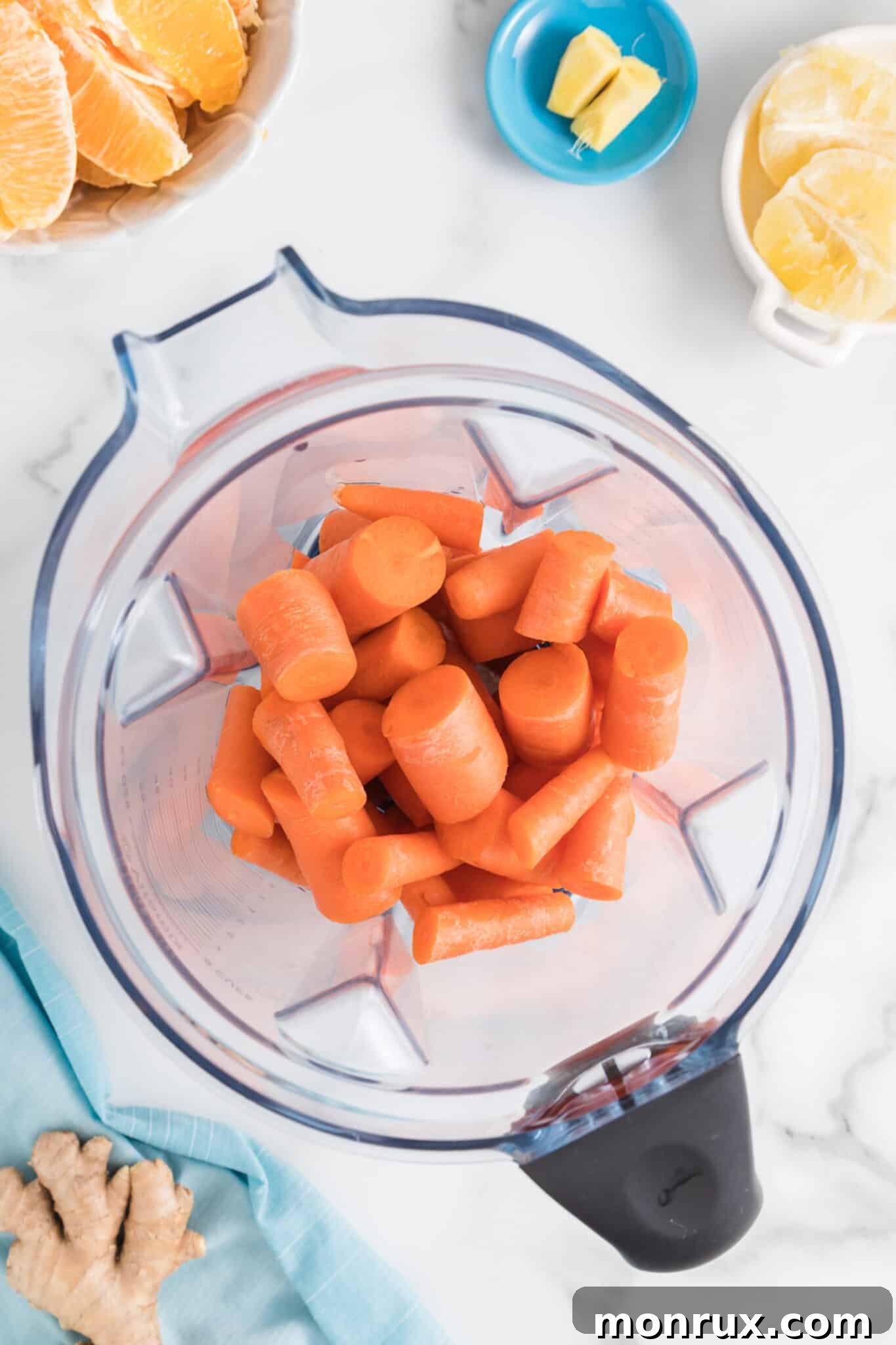 Chopped carrots placed into a blender jar, ready for juicing.