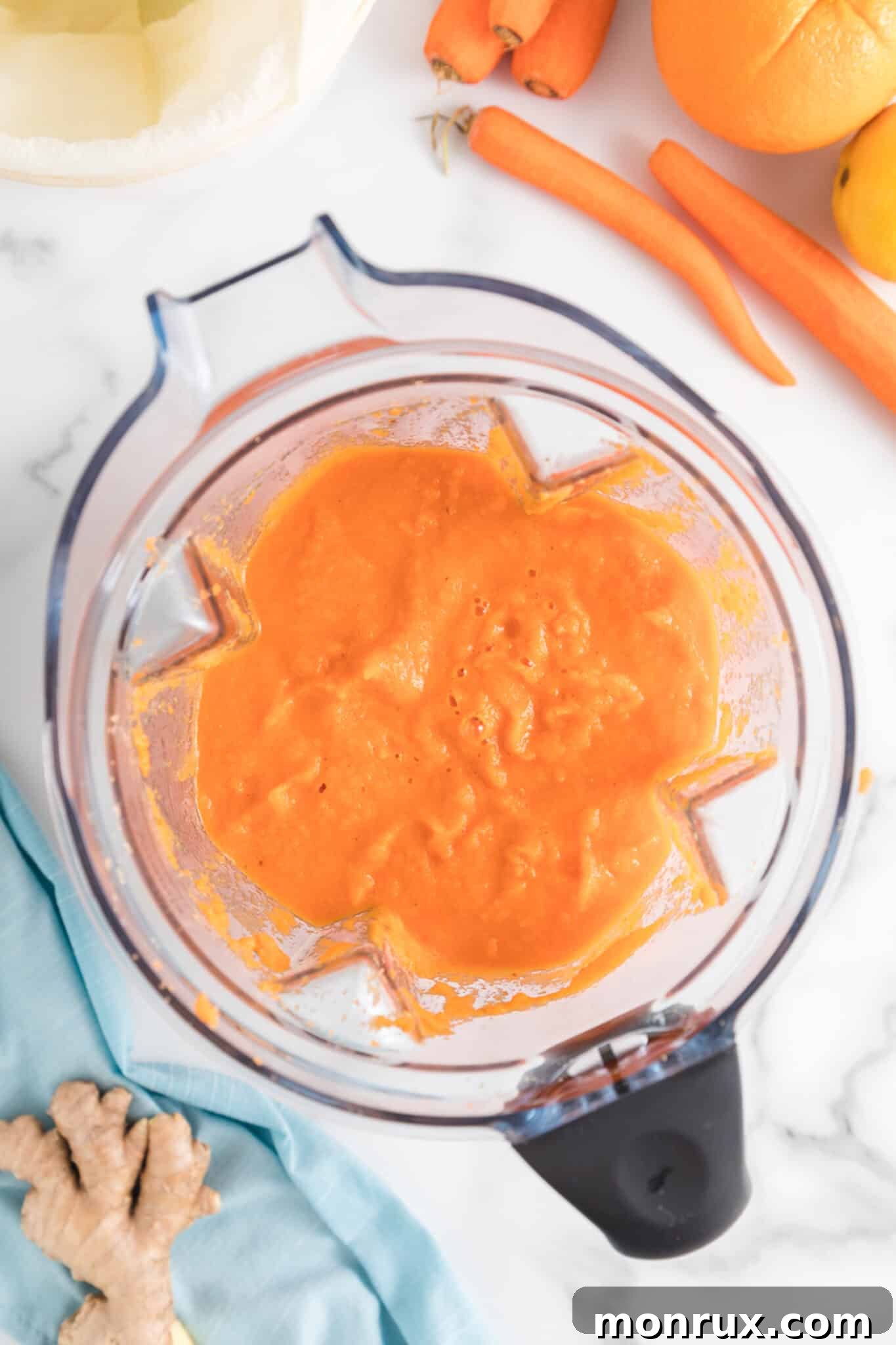Blended mixture of carrots, oranges, and ginger, showing a smooth, frothy consistency.