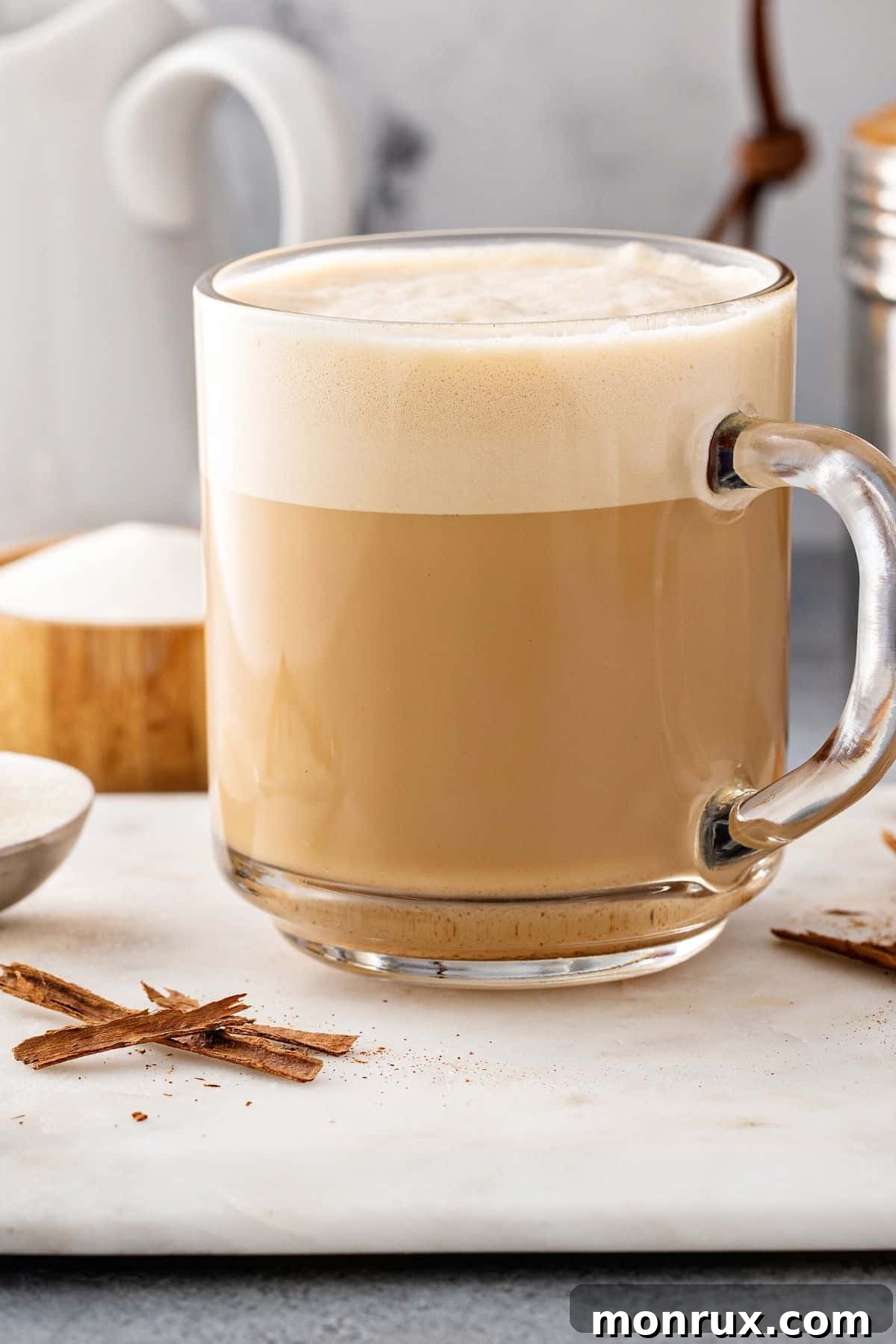 A clear glass mug of protein coffee topped with foam, inviting you to start your day with energy.
