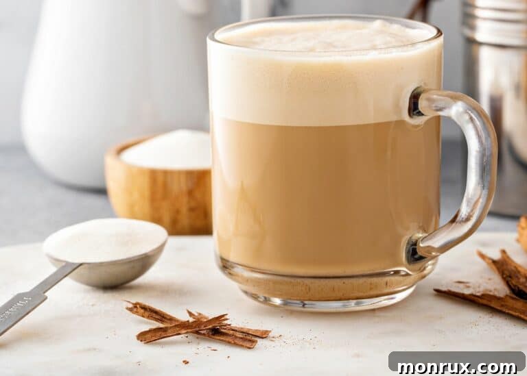 A clear glass mug of protein coffee topped with foam, ready to be enjoyed.