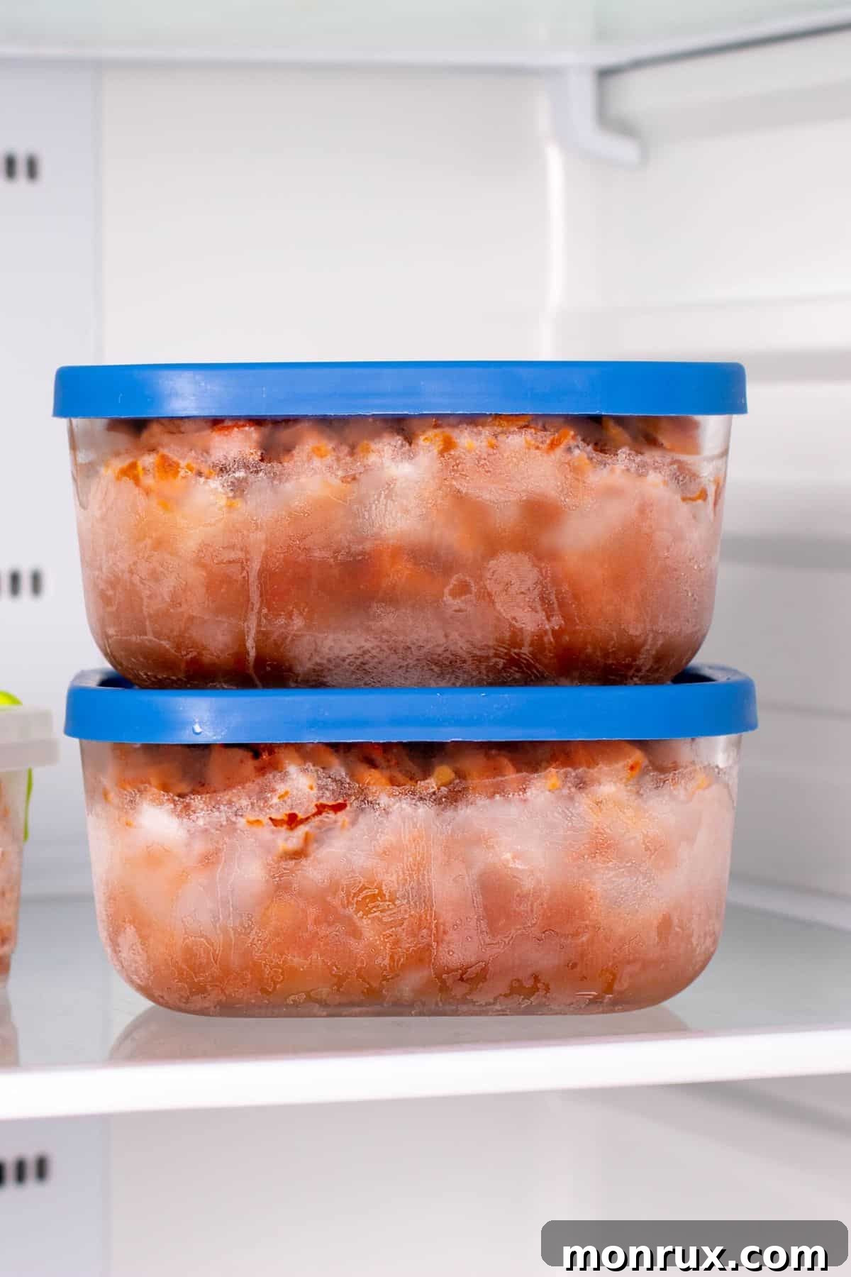 Frozen beef stew in square containers with blue lids, ready for the freezer.
